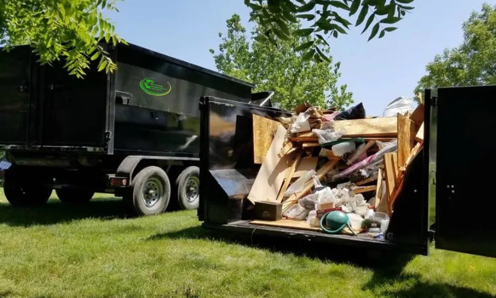 Dump trailer loaded with renovation debris on a lawn