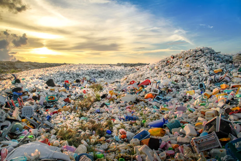Sorted waste and recyclables at a landfill at sunset